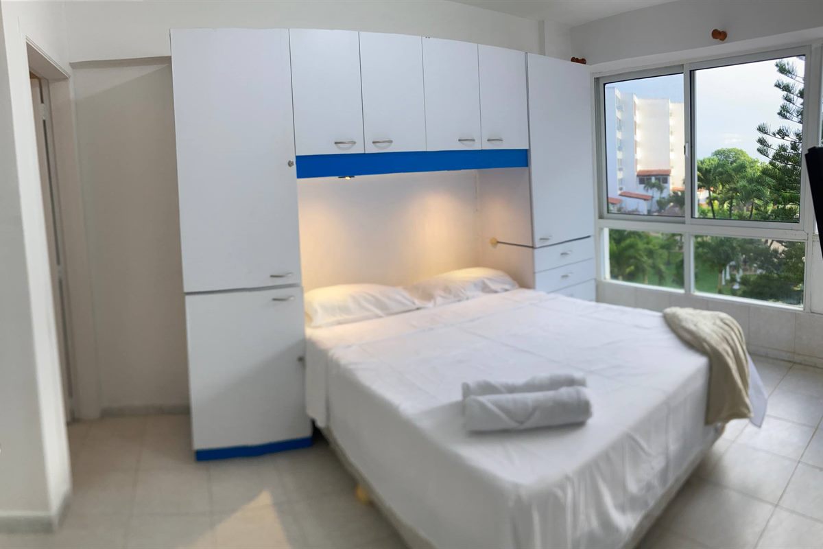Habitación con cama vestida en blanco
