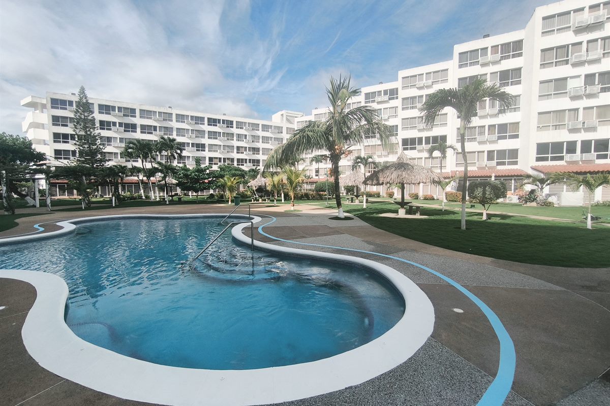 Piscina tipo laguna rodeada de jardines en El AguaSal II