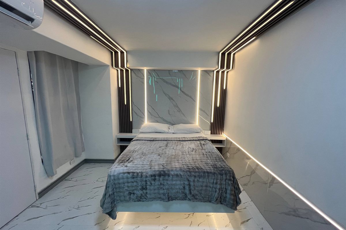 Habitación contemporánea con iluminación LED y acabados en mármol