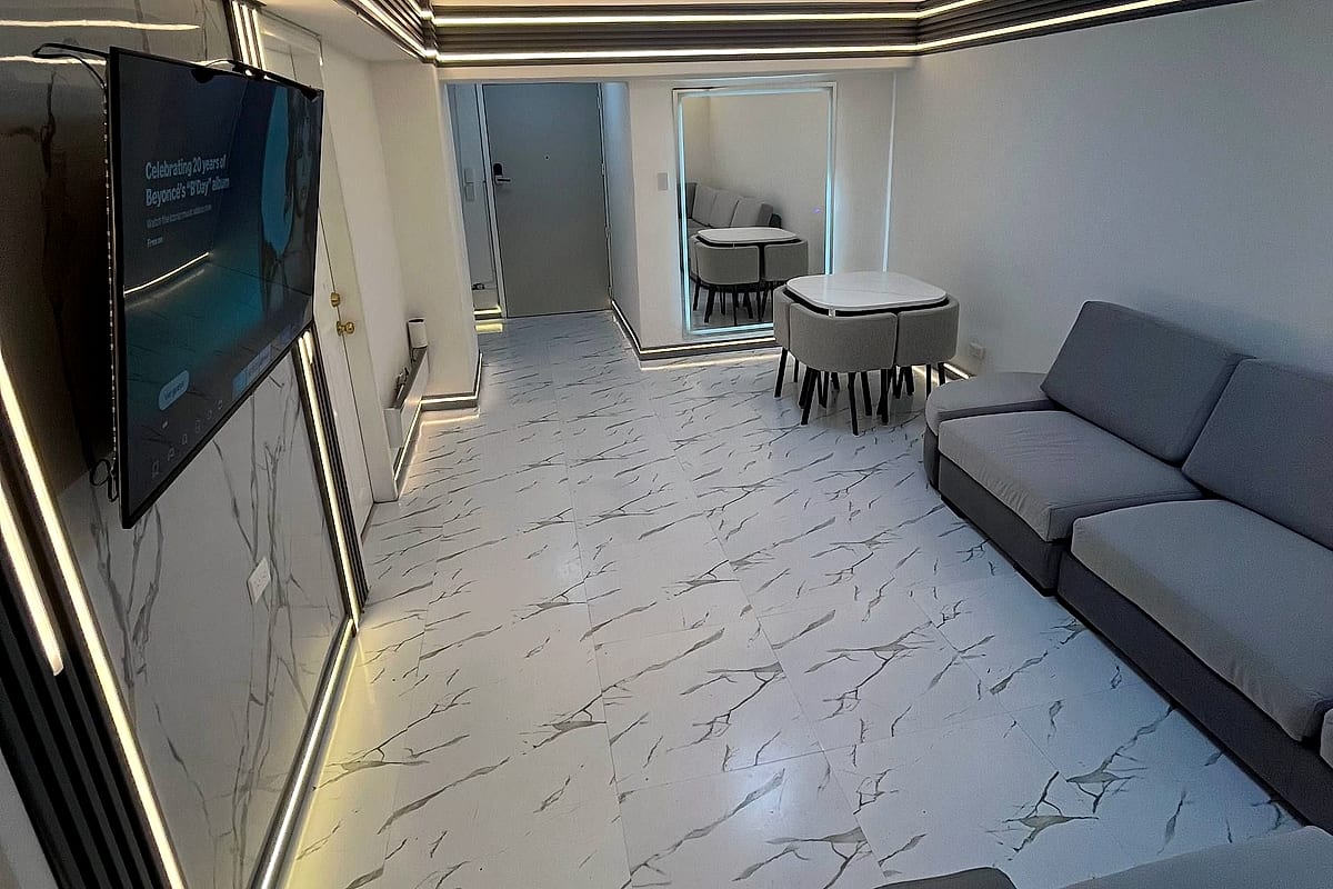 Sala de estar con molduras LED y piso de mármol