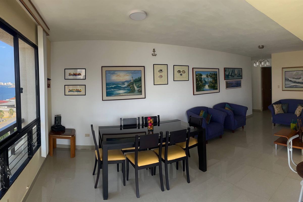 Sala comedor con ventanal y vista al mar en Macuto