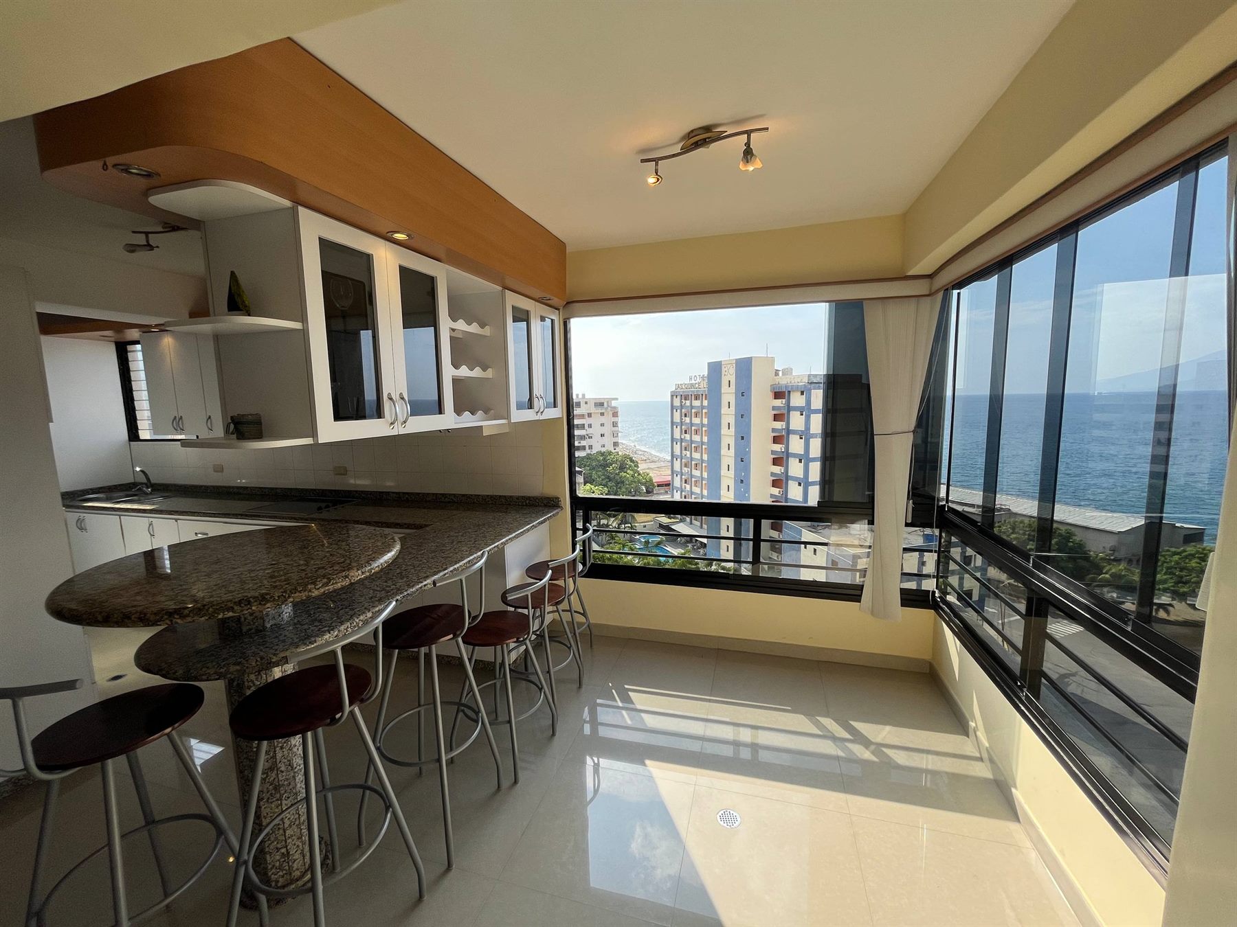 Barra y ventanal con vista al mar en una propiedad administrada por Genuino Host
